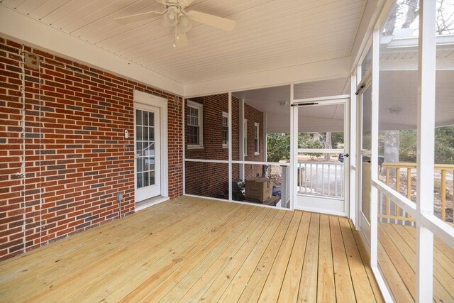 unfurnished sunroom with ceiling fan