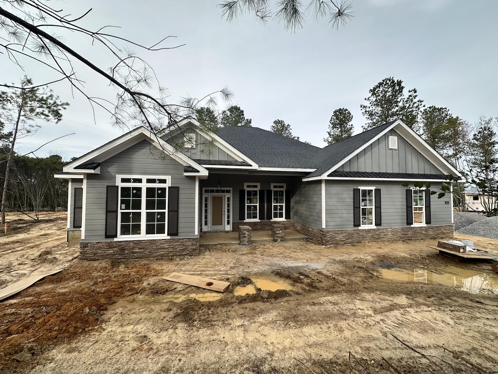 view of front facade featuring a shingled roof and board and batten siding