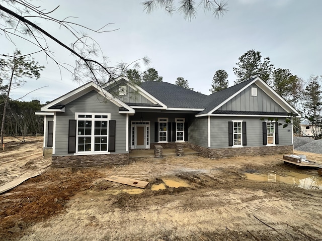 view of front facade featuring a shingled roof and board and batten siding