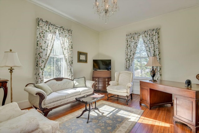 living room with an inviting chandelier, light hardwood / wood-style floors, and a healthy amount of sunlight