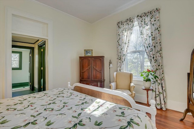 bedroom with crown molding and light wood-type flooring