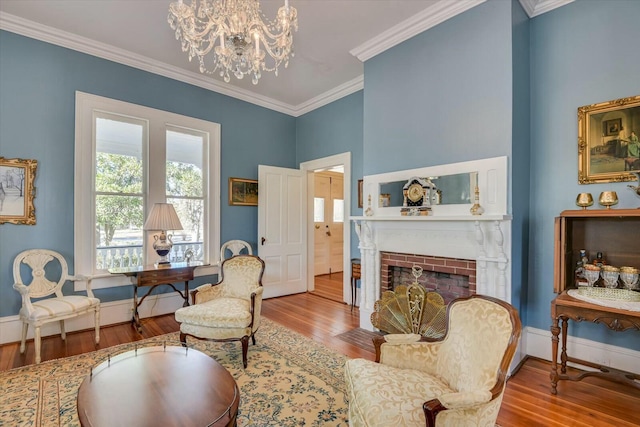 sitting room with ornamental molding, wood-type flooring, and a brick fireplace