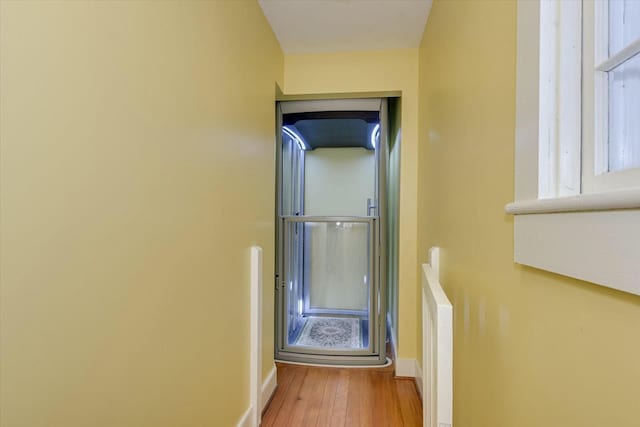 corridor with hardwood / wood-style flooring