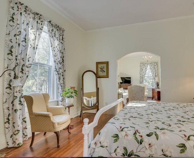 bedroom with ornamental molding, wood-type flooring, and multiple windows