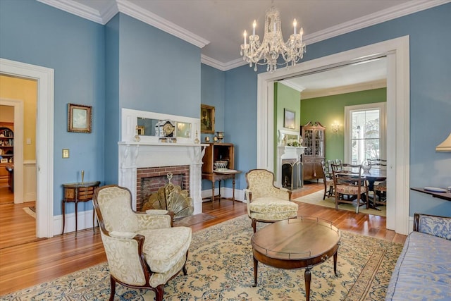 living room with a fireplace, ornamental molding, a chandelier, and wood-type flooring