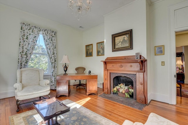 sitting room featuring wood-type flooring, a brick fireplace, and a chandelier