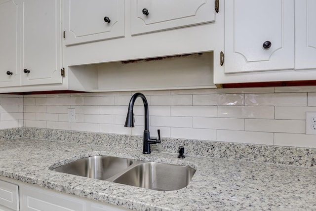 3831 Highpointe Dr, Hephzibah, GA 30815 - kitchen view of white cabinetry, decorative backsplash, and light stone counters