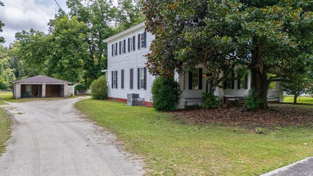 view of front of home with central air condition unit and a front yard