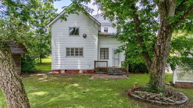 rear view of property with a lawn