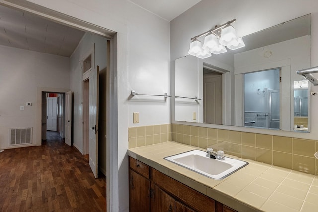 bathroom with tasteful backsplash, vanity, and hardwood / wood-style flooring