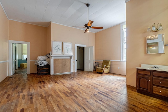 interior space with ceiling fan, ornamental molding, and light wood-type flooring