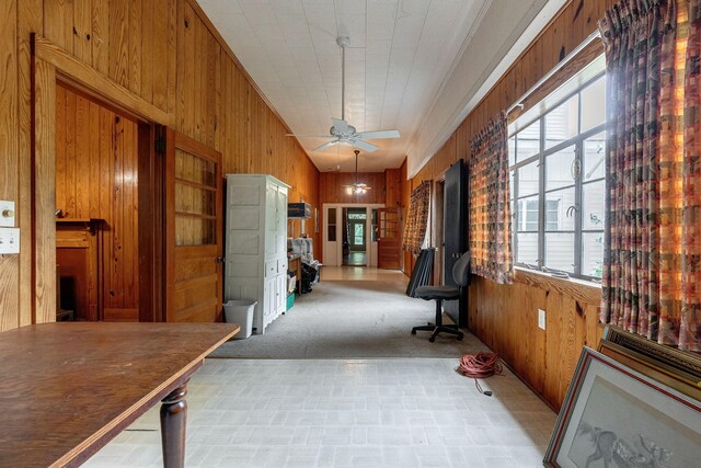 corridor featuring wooden walls and light carpet