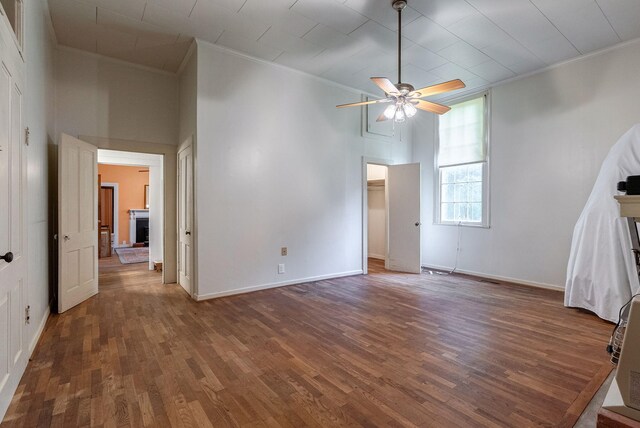 interior space with dark hardwood / wood-style flooring, ceiling fan, and crown molding