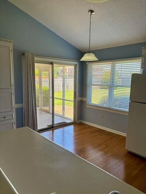 2949 Hillcreek Dr, Augusta, GA 30909 - unfurnished dining area with lofted ceiling, hardwood / wood-style flooring, baseboards, and a textured ceiling