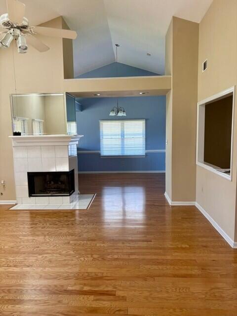 2949 Hillcreek Dr, Augusta, GA 30909 - unfurnished living room featuring vaulted ceiling, a ceiling fan, a fireplace, a chandelier, and wood finished floors