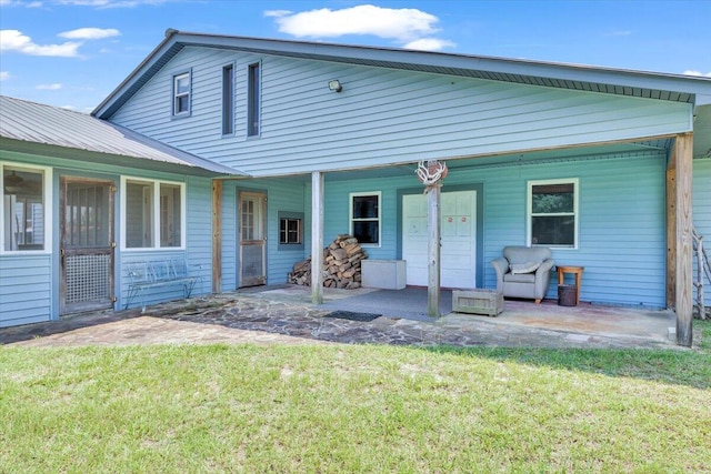 back of house with a yard and a patio