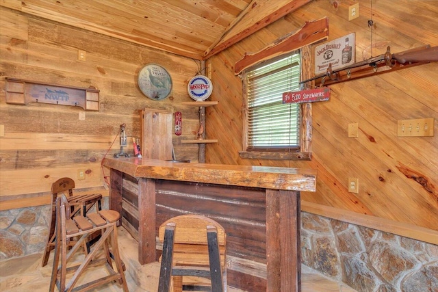 bar with wood walls, wood ceiling, and lofted ceiling