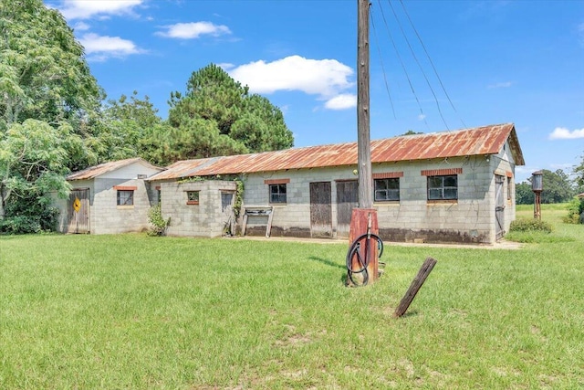 back of property with a yard and an outdoor structure