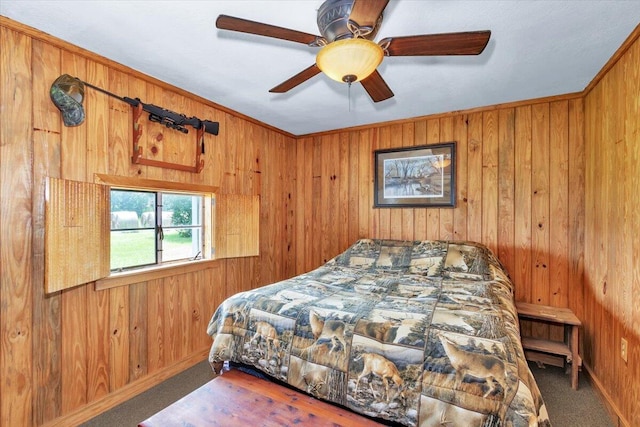 bedroom featuring ceiling fan, wooden walls, and carpet floors