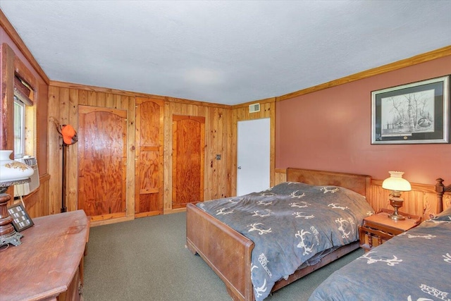 bedroom featuring dark colored carpet, ornamental molding, and wood walls