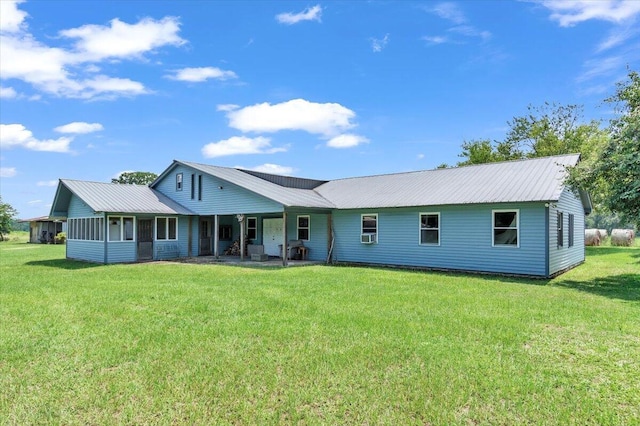 rear view of house with a sunroom and a yard