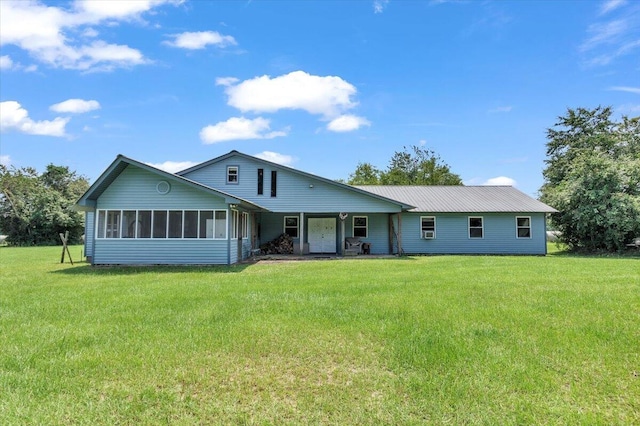 rear view of house featuring a lawn and a sunroom