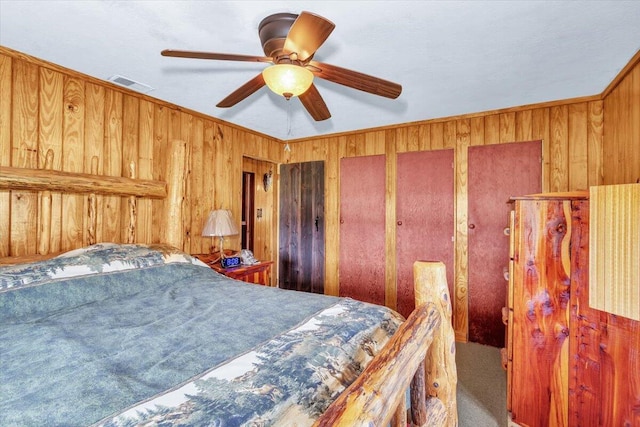 bedroom with ceiling fan, ornamental molding, and wooden walls