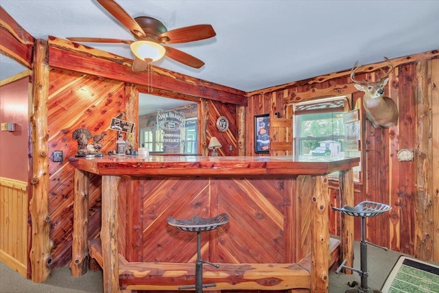 bar with carpet, ceiling fan, and wood walls