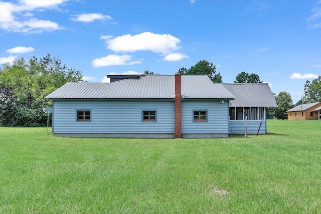 rear view of house with a sunroom and a lawn