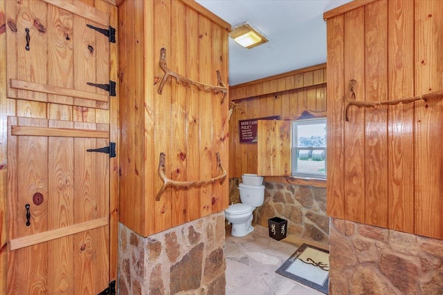 bathroom with wood walls and toilet