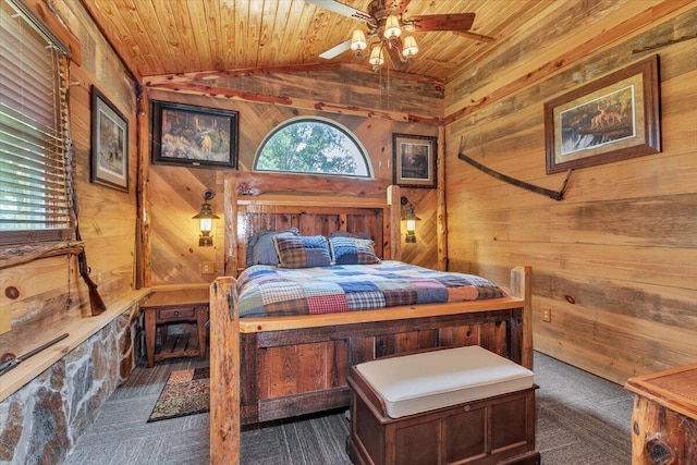 bedroom with vaulted ceiling, ceiling fan, wooden ceiling, and wood walls