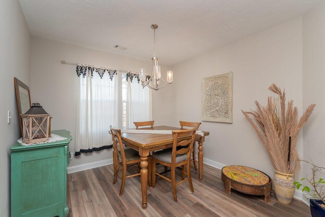 dining area featuring dark hardwood / wood-style floors and a chandelier