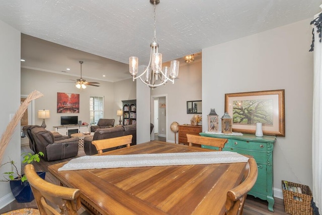 dining area with hardwood / wood-style floors, ceiling fan with notable chandelier, and a textured ceiling