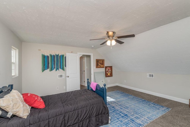 carpeted bedroom with vaulted ceiling, ceiling fan, and a textured ceiling