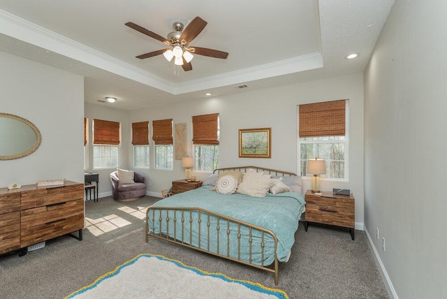 bedroom featuring multiple windows, crown molding, light carpet, and a tray ceiling