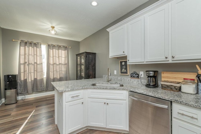 kitchen with sink, white cabinetry, light stone countertops, stainless steel dishwasher, and kitchen peninsula