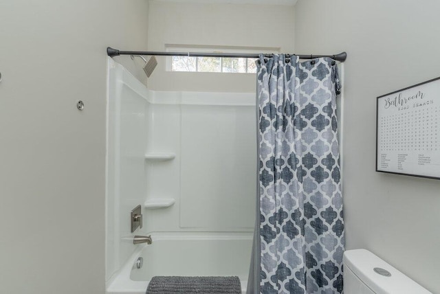 bathroom with shower / bath combination with curtain and toilet