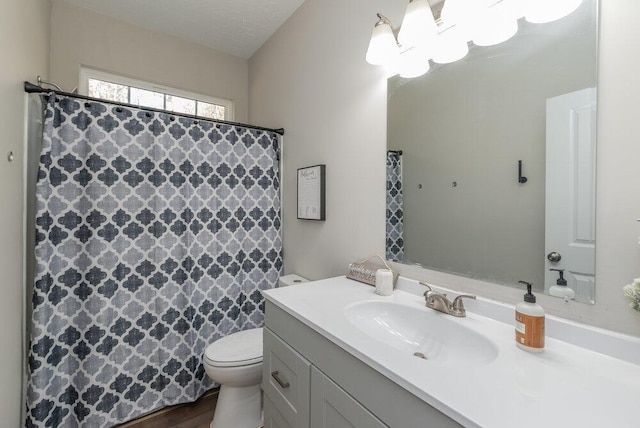 bathroom with vanity, toilet, hardwood / wood-style floors, and a textured ceiling