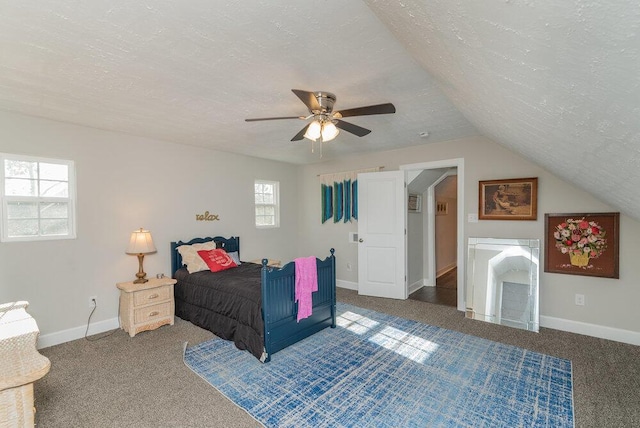 bedroom with multiple windows, ceiling fan, dark carpet, and a textured ceiling