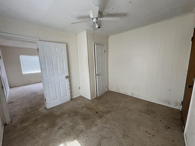 unfurnished bedroom with carpet, ceiling fan, and a textured ceiling