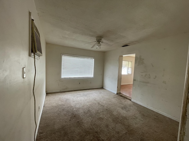 unfurnished bedroom with carpet, visible vents, a textured ceiling, and baseboards