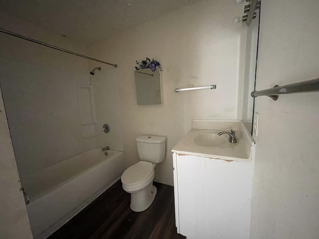 full bath with toilet,  shower combination, wood finished floors, and vanity