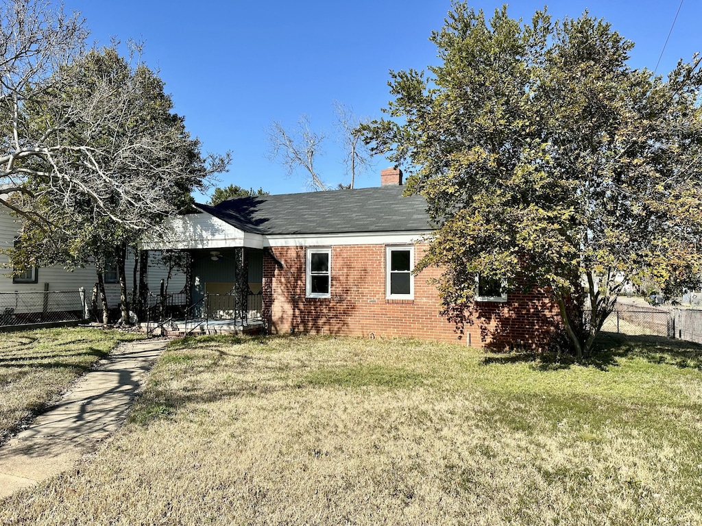 rear view of property featuring a lawn