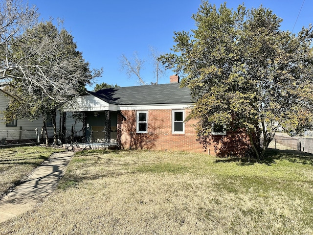 rear view of property featuring a lawn