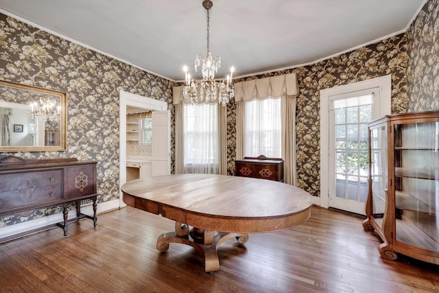 1203 Highland Ave, Augusta, GA 30904 - dining space with plenty of natural light, a chandelier, hardwood / wood-style flooring, wallpapered walls, and crown molding