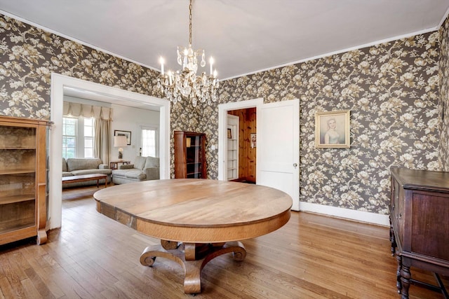 1203 Highland Ave, Augusta, GA 30904 - dining room featuring wallpapered walls, wood finished floors, ornamental molding, and a chandelier