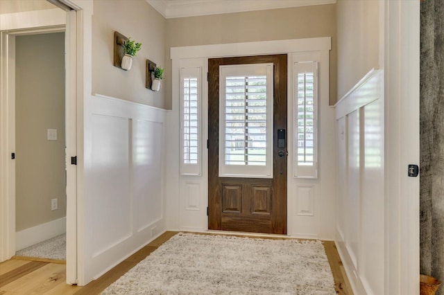 entryway featuring crown molding and light hardwood / wood-style floors