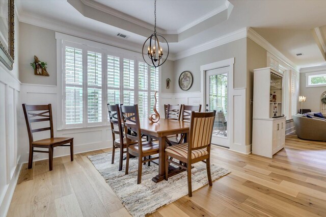 dining area featuring light hardwood / wood-style floors, a wealth of natural light, and a tray ceiling