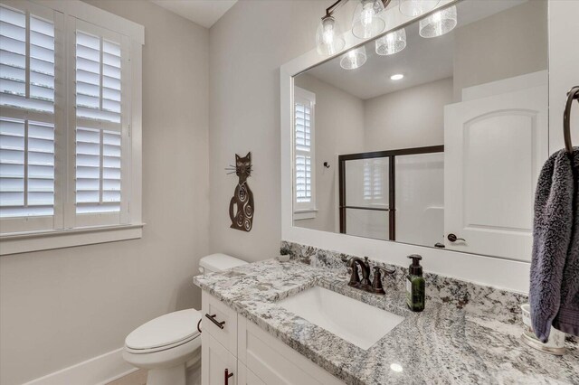 bathroom featuring plenty of natural light, toilet, and vanity