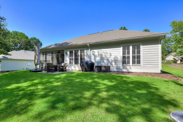 rear view of property with a lawn, ceiling fan, and a patio